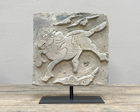 Antique decorative brick with a horse and clouds